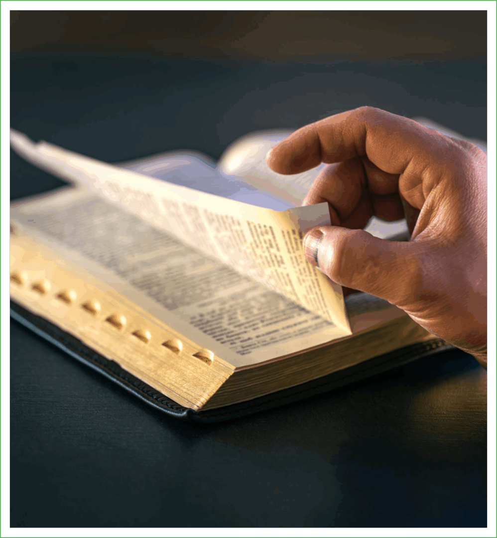 Hand flipping pages of an open book.